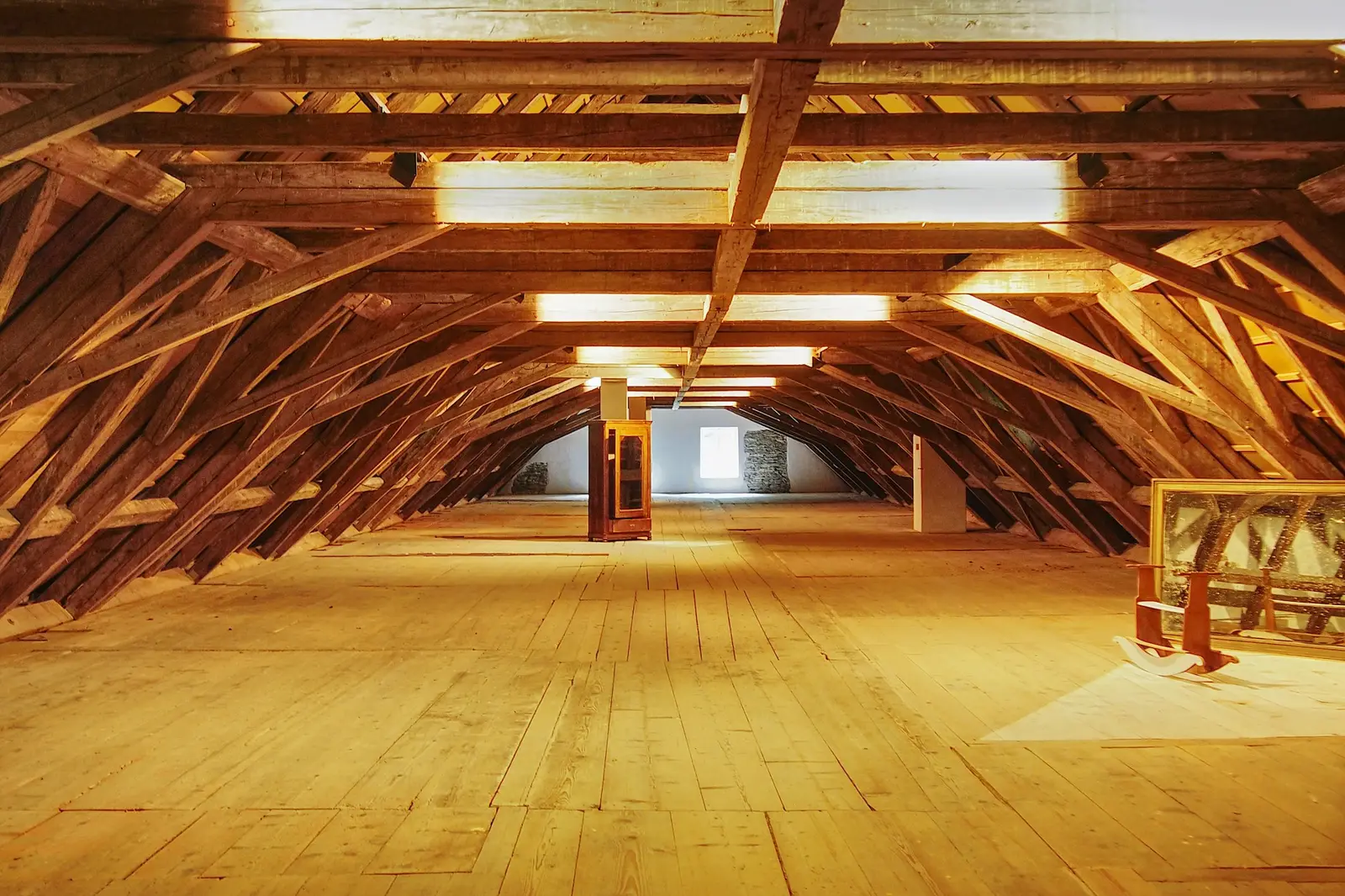 Heller, leerer Dachboden mit Holzbalken und Dielenboden